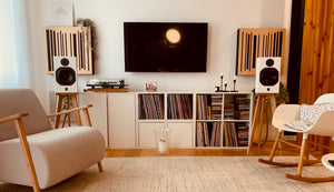 A pair of wooden speaker stands for the ATC SCM11 speakers, positioned in a living room setting.