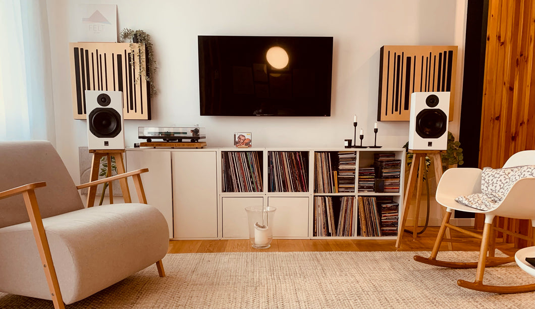A pair of wooden speaker stands for the ATC SCM11 speakers, positioned in a living room setting.