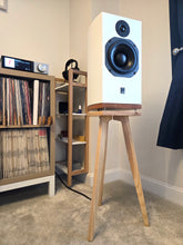 Load image into Gallery viewer, White aTC SCM1 speaker on an ash  700mm wooden speaker stand by audio chic in a room with shelves and records.
