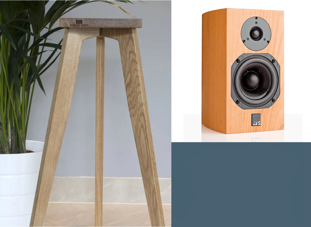 An ATC SCM7 shaped speaker on an oak wood stand with a tripod base, positioned in a home environment. The stand heights are adjustable from 140-900mm for optimal audio performance.