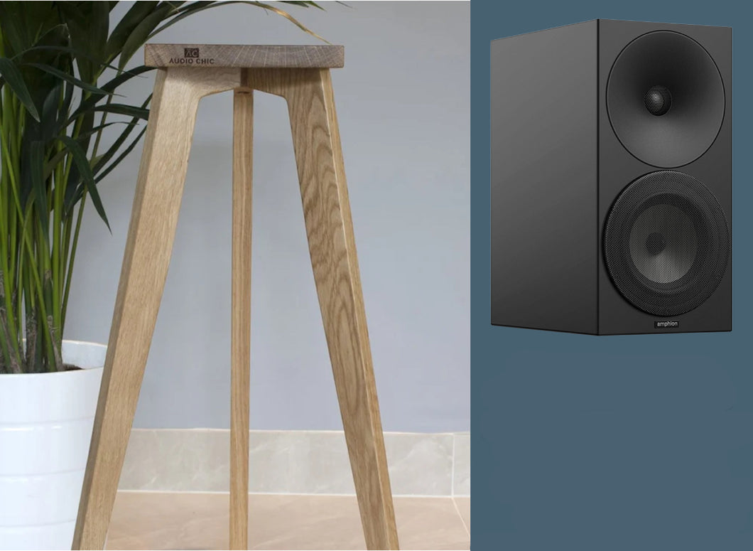 Amphion Argon 3S bookshelf loudspeakers on an oak stand, with a three-legged design. The loudspeakers are black, and the stand is a natural oak color.