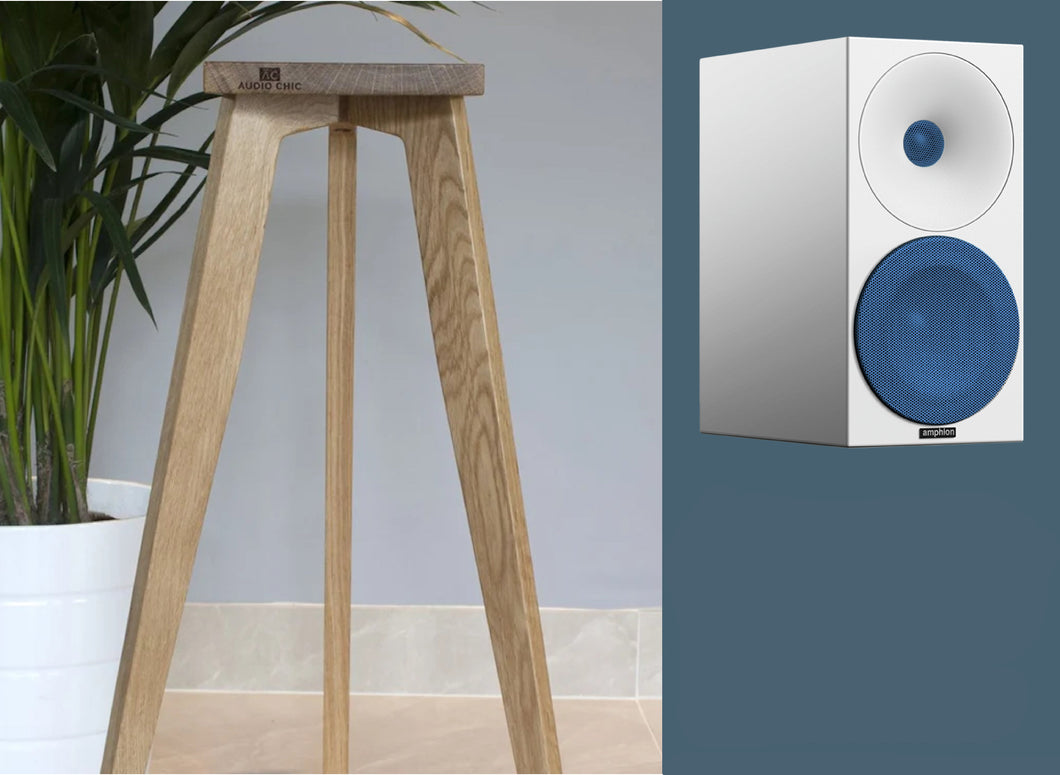 Amphion Helium510 bookshelf loudspeaker on a three-legged stand, in oak finish. The speaker stands in a home environment.