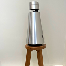 Load image into Gallery viewer, B-and-O-Beosound-1-speaker-egret-speaker-stand-by-audio-chic against a white wall.