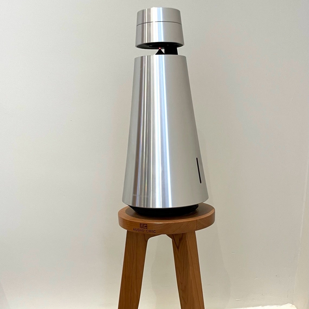 B-and-O-Beosound-1-speaker-egret-speaker-stand-by-audio-chic against a white wall.