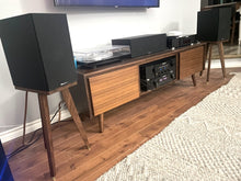 Load image into Gallery viewer, Wooden entertainment console with speakers on a pair of speaker stands in walnut by audio chic in a room setting