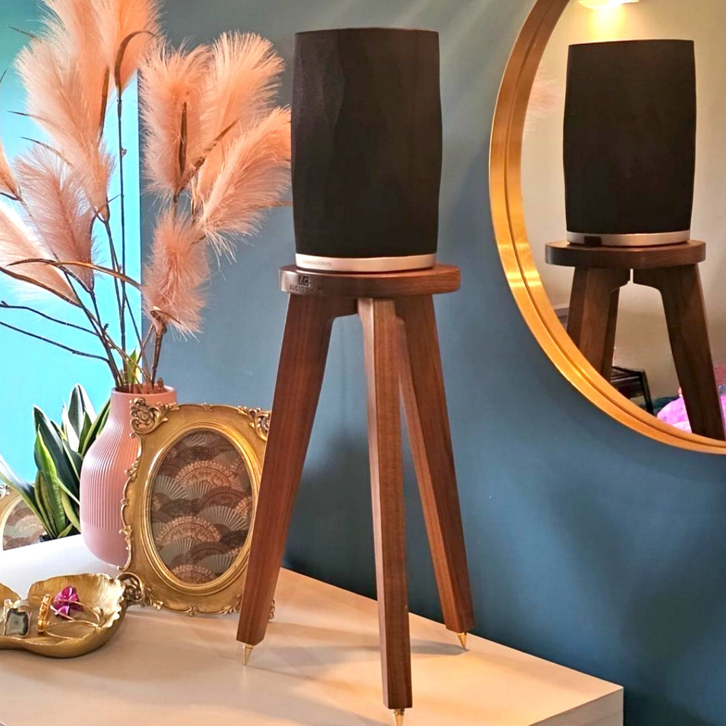 B-and-W-Formation-Flex-Egret-speaker-stand-in-Walnut-by-audio-chic against a blue wall