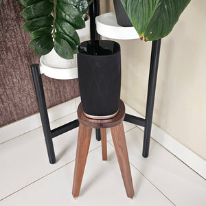 B-and-W-Formation-Flex-Egret-speaker-stand-in-Walnut-by-audio-chic against a blue wall