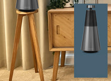 Load image into Gallery viewer, A B&amp;O Beosound 2 speaker mounted on a circular speaker stand, with the stand made of timber placed on a floor. There&#39;s an inset image showing the speaker.
