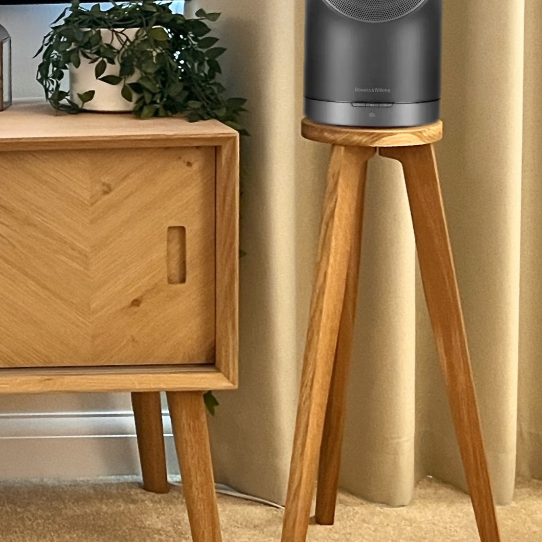 Wooden speaker stand with a black B&W Formation Duo speaker on a beige carpeted floor.