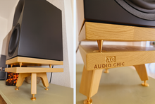 Load image into Gallery viewer, Wooden speaker stand with &#39;Audio Chic&#39; branding, holding a black speaker.