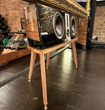 Load image into Gallery viewer, Shaped Walnut speaker stand by Audio Chic for the large Dali Epicon Vokal Centre Speaker, set in a stylish dark room with a dark floor and brick wall
