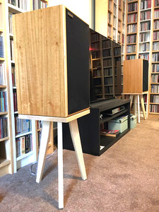 Harbeth-M30.2-XD-500-egret-speaker-stand-in-maple-by-audio-chic in a room with bookshelves.