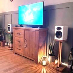 Harmony-oak-speaker-stands-by-audio-chic-with-Audio-Engine-A5_-speakers and a Wooden entertainment console with TV in a room setting