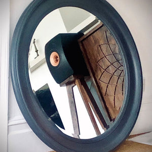 Round mirror with a blue frame reflecting a room interior with KEF-LS50-Metas-snipe-speaker-stands-in-Walnut-with-Plinths-by-audio-chic