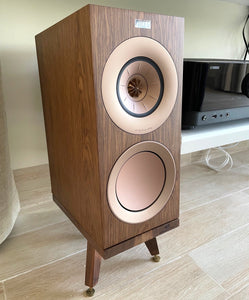 Wooden KEF R3 speaker on a Snipe speaker stand by Audio Chic on a light wooden floor.