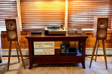 Load image into Gallery viewer, Living room with a wooden entertainment console, KEF R3 speakers on Walnut speaker stands, and blinds.