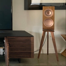 Load image into Gallery viewer, Living room setup with a TV, KEF R3 speakers on Audio Chic walnut speaker stands, and a lamp.