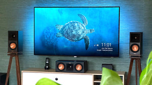 Klipsch-RP500M-II-Walnut-with-plinths-speaker-stands-by-audio-chic. TV screen displaying a turtle image with speakers on either side in a room.