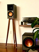 Load image into Gallery viewer, Pair of Klipsch RP600M speakers with walnut crane speaker stands from Audio Chic and a subwoofer in a home setup.