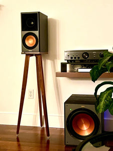 Pair of Klipsch RP600M speakers with walnut crane speaker stands from Audio Chic and a subwoofer in a home setup.