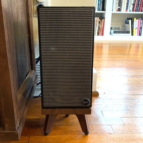Klipsch-The-Fives-Speaker-Snipe-speaker-Stand-by-audio-chic in a room with a wooden floor and bookshelf