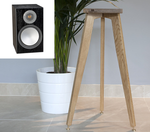 Wooden speaker stand with a plant and a black monitor audio silver 100 speaker in a room setting.