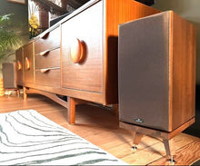 Load image into Gallery viewer, Monitor-Audio-Bronze-BR-2-Walnut-Snipe-speaker-stand with Wooden sideboard in a room setting