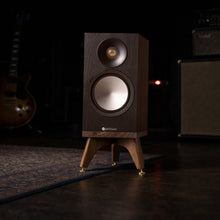 Load image into Gallery viewer, Wooden Monitor Audio Bronze 50 7G speaker on a snipe speaker stand in a dark room with musical equipment.