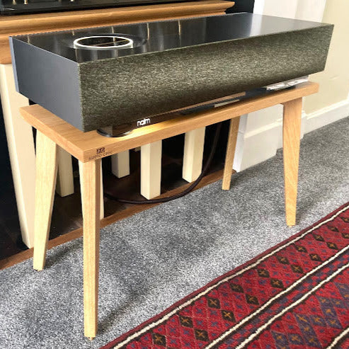 Naim-Audio-mu-so-2nd-centre-speaker-stand-by-audio-chic in a room setting.