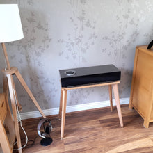 Load image into Gallery viewer, Naim-Audio-mu-so-2nd-centre-speaker-stand-by-audio-chic with Wooden side table, lamp, and wooden cabinet in a room.