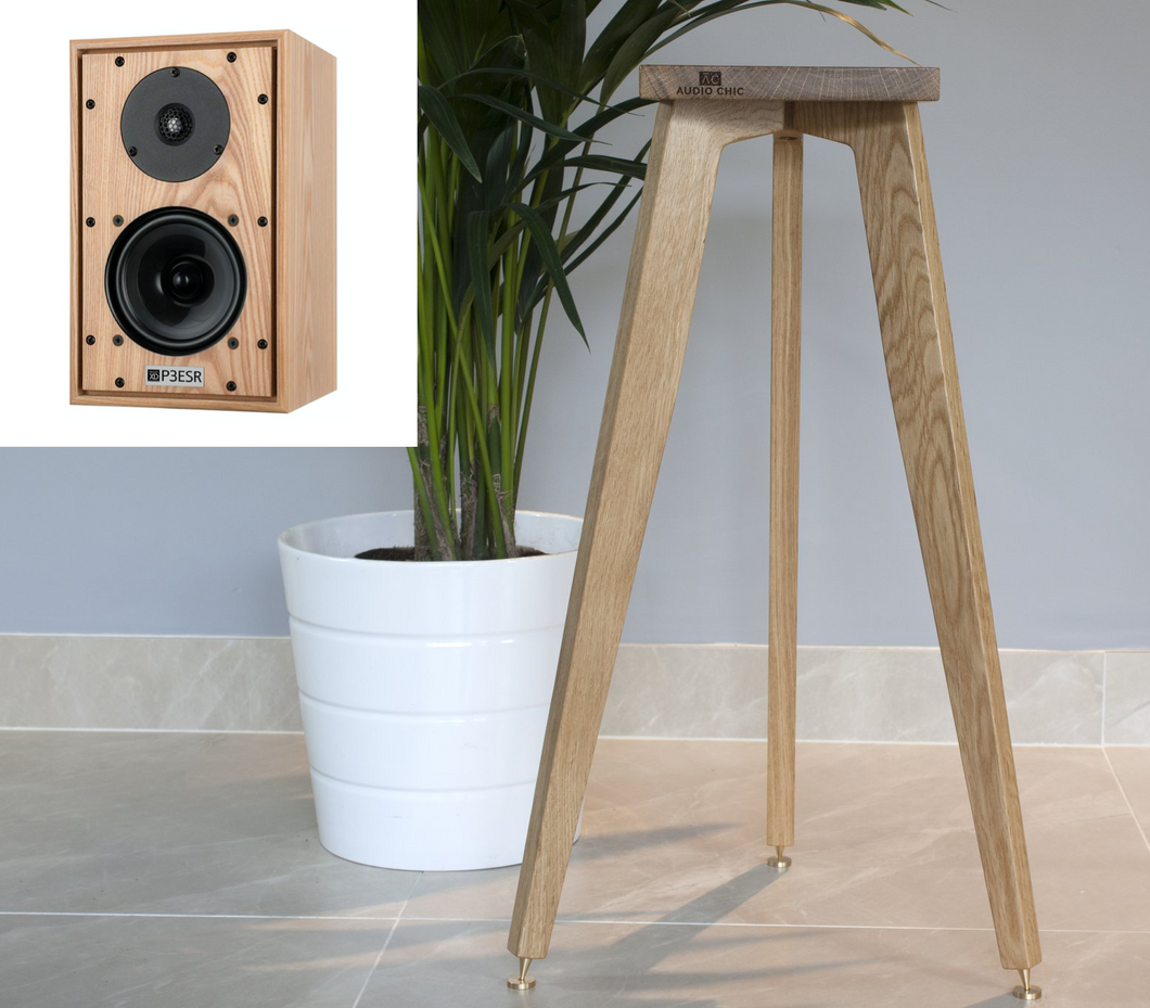 Wooden speaker stand and Harbeth P3ESR speaker, plant, against a light gray wall.