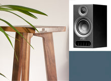 Load image into Gallery viewer, A black PMC Prodigy 1 speaker with a walnut Audio Chic speaker stand, with a plant in the background.