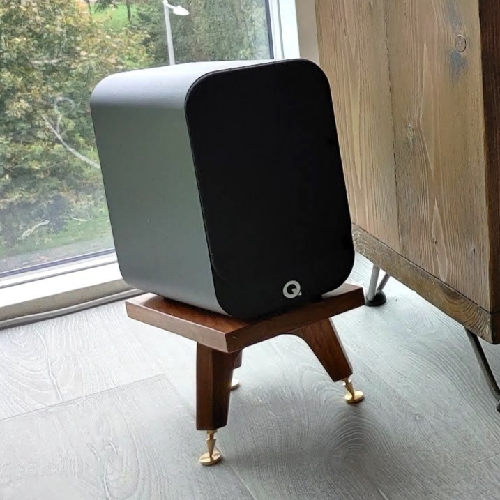 Q-acoustics-3010i-snipe-speaker-stands-in-walnut-by-audio-chic Modern room with a window and wooden furniture.