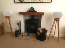Load image into Gallery viewer, Sonos-Era-300-oak-speaker-stands-with-plinths-by-audio-chic in front of a wood stove and wood basket.