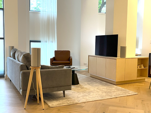 Sony-HT-A9-Heron-700mm-speaker-stands-in-Maple-by-audio-chic in a very modern living room with vaulted ceilings.