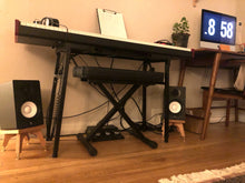 Load image into Gallery viewer, Yamaha-HS5-drunken-kite-speaker-stand-in-cherry-by-audio-chic in a music room with an electronic piano and workstation.